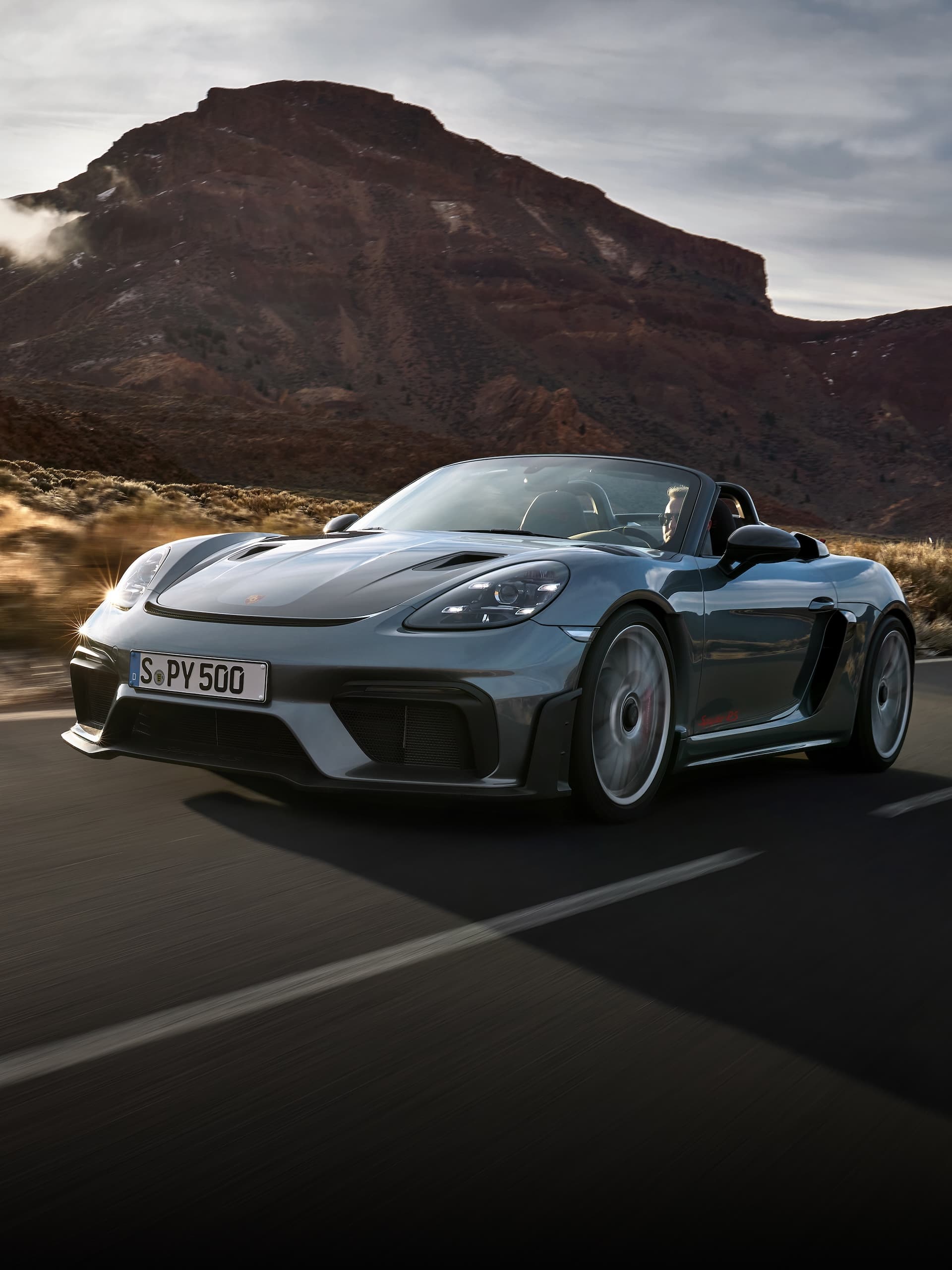 Porsche 718 Spyder RS kjører på veien mellom steinformasjoner.